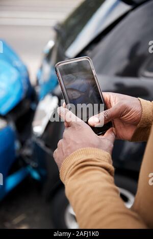 Automobiliste mâle impliqué dans Accident de voiture Prendre photo de dommages pour réclamation d'assurance Banque D'Images