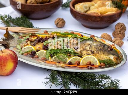 Carp avec citron, les noix et les raisins secs sur la plaque Banque D'Images