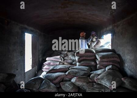 Le Pendjab, en Inde. Dec 16, 2019. Décharger les sacs de ciment ouvriers des trains de marchandises à la jonction ferroviaire dans la province du Punjab, en Inde. Credit : Saqib Majeed/SOPA Images/ZUMA/Alamy Fil Live News Banque D'Images