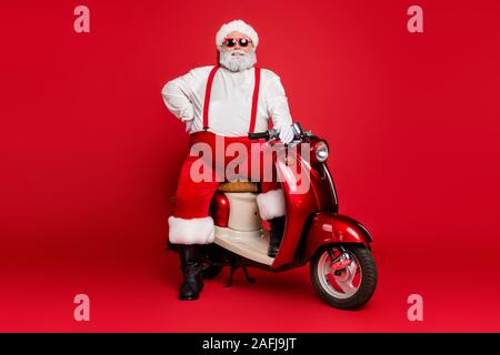 Portrait de son joyeux barbu nice il fat funky joyeux Père Noël surdimensionnés hipster assis sur moto fête d'hiver isolé sur vivid lumineux Banque D'Images