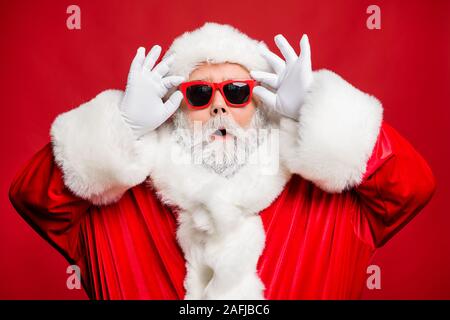 La photo en gros plan de l'impressionné funny santa claus ont de mauvais yeux me demande de fête incroyable négocier porter des gants blancs à la mode élégante sur rouge isolé Banque D'Images