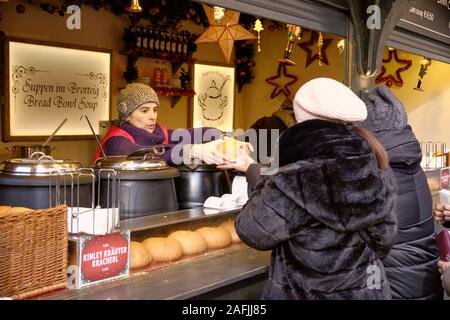 Femme de servir la soupe dans un bol de pain au marché de l'avent de Vienne pour le client Banque D'Images