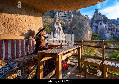 Femme en robe bohème assis sur traditional house en Cappadoce, Turquie. Banque D'Images