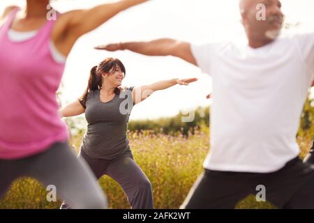 Groupe d'âge Hommes et femmes de sa catégorie dans la retraite de yoga en plein air Banque D'Images