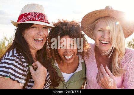 Portrait Of Mature Female Friends Walking Through Field sur Camping Locations Banque D'Images