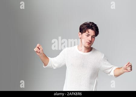 Studio Portrait of Young Man having fun Dancing à l'appareil photo Banque D'Images