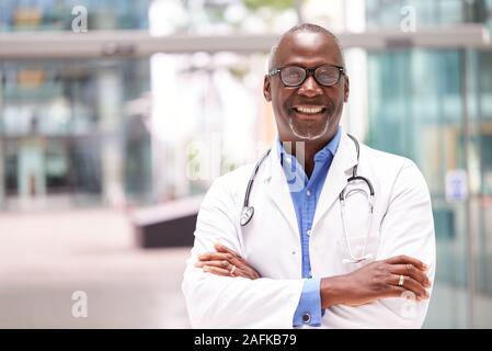 Portrait Of Male Doctor with Stethoscope Wearing White Coat debout dans la construction de l'hôpital moderne Banque D'Images