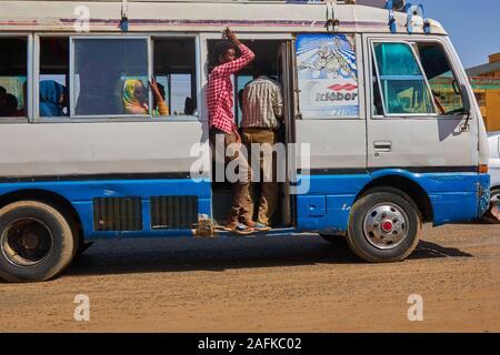 Khartoum, Soudan, ca. Le 8 février, 2019. Les passagers : Lecteurs de minibus à travers les rues de Khartoum avec les portes ouvertes Banque D'Images