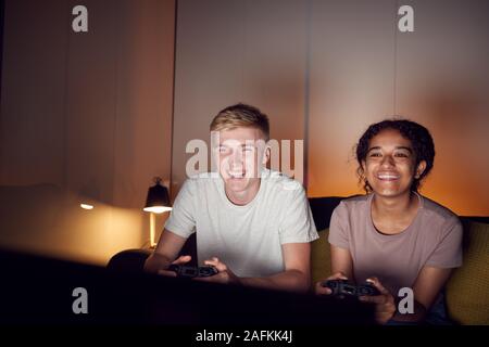 Teenage Couple Sitting on Sofa At Home Ensemble de jeux vidéo Banque D'Images