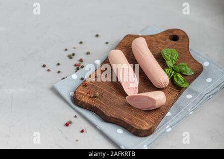 Pour le petit-déjeuner saucisses et hot-dogs. Sur un fond clair. A proximité, les feuilles de basilic. Banque D'Images