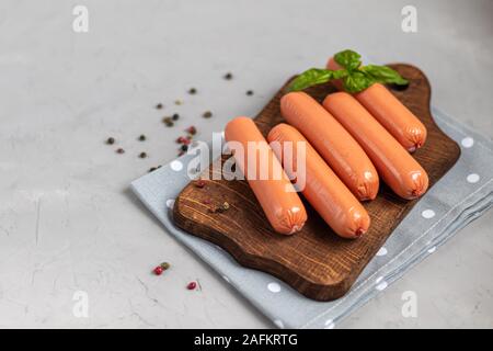 Pour le petit-déjeuner saucisses et hot-dogs. Sur un fond clair. A proximité, les feuilles de basilic. Banque D'Images