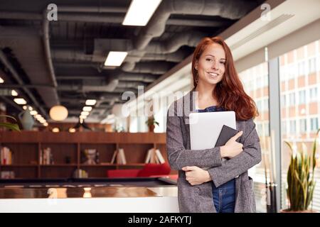 Portrait of young woman en passant habillé en milieu de travail moderne Banque D'Images