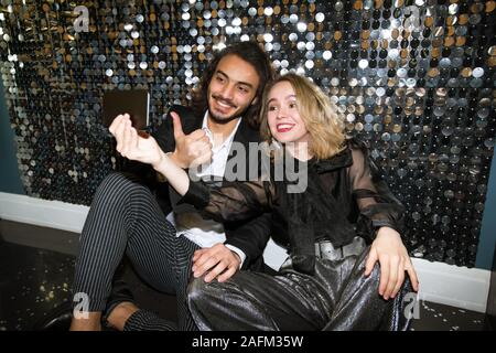 Cheerful young couple bien habillé en selfies parti dans le night club Banque D'Images