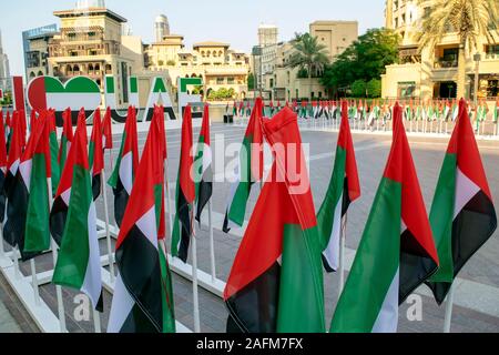 Dubaï / Emirats Arabes Unis - 3 décembre 2019 : beaucoup de drapeaux nationaux des EAU avec Souk Al Bahar sur l'arrière-plan. J'aime les mots des EAU et de signer. Journée nationale des EAU. Le jour du drapeau. Banque D'Images