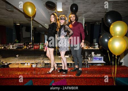 Deux jolies filles et guy standing élégant sur le comptoir en restaurant de luxe Banque D'Images