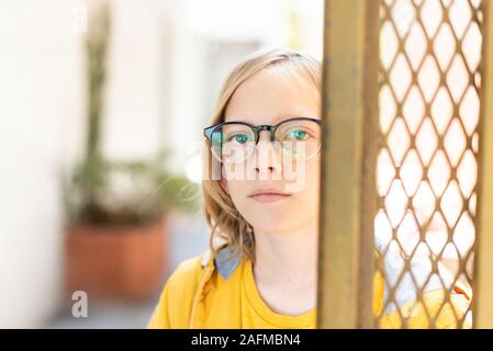 Portrait de tween à autour du coin de la porte des lunettes Banque D'Images