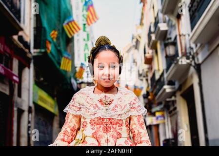 Belle fille fallera portant le costume de Fallas Valencienne traditionnelle, au cours d'une session de beauté et posant à l'extérieur. Banque D'Images