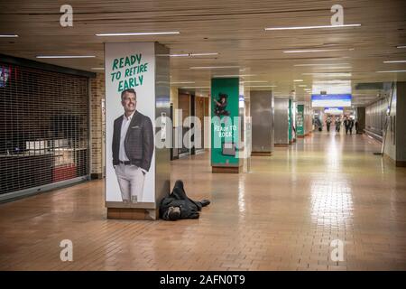 Sans-abri dormir sur le plancher du hall de métro, Philadelphia, USA Banque D'Images