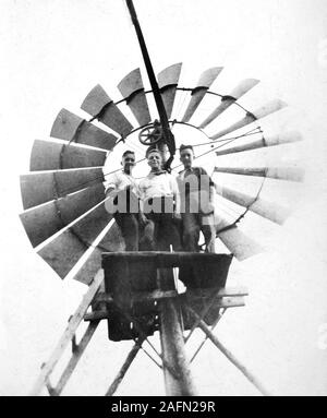 Trois garçons posent fièrement sur leur plate-forme de maison en haut d' une ferme éolienne dans le Dakota du Sud, ca. 1938. Banque D'Images