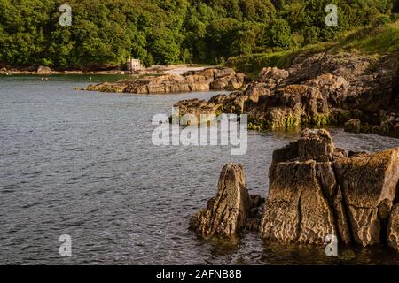 Marcher vers Elberry Cove, Torbay, Angleterre, Royaume-Uni - avec l'ancienne baignoire-maison sur le bord de la plage de galets Banque D'Images