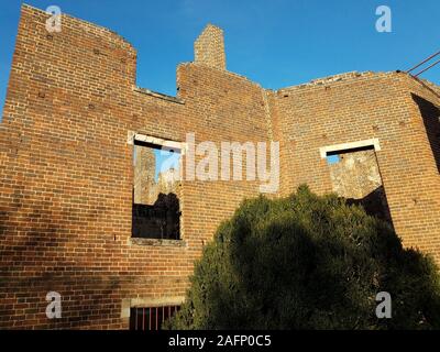 Vieille maison de briques rouges délabrées ou structure en ruines Banque D'Images