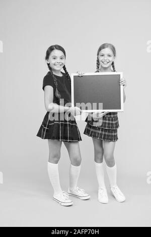 Cours de Cheerleading. School girls cute pupils uniforme rouge tenir copie tableau noir l'espace. Annonce école concept. Équipe de l'initiative de camarades. Inscrivez-vous le club scolaire. Les élèves de la communauté. L'annexe de l'école. Banque D'Images