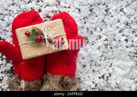 Gants d'hiver avec boîte-cadeau de Noël. Maison de fond avec décoration de fête bal, flocons de pommes de pin, de l'arrière-plan de mise à plat, vue du dessus. Spa Banque D'Images