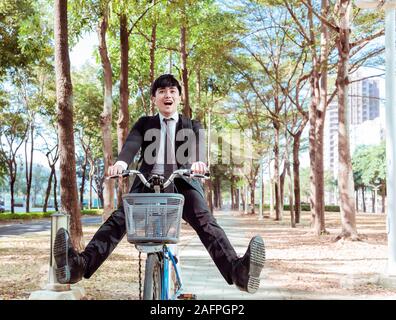 Happy Businessman riding bicycle pour travailler sur la rue en milieu urbain Banque D'Images