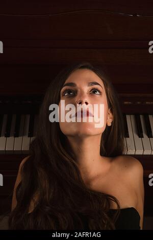 Vue rapprochée d'une jeune fille jusqu'à la pensée et de la musique Banque D'Images