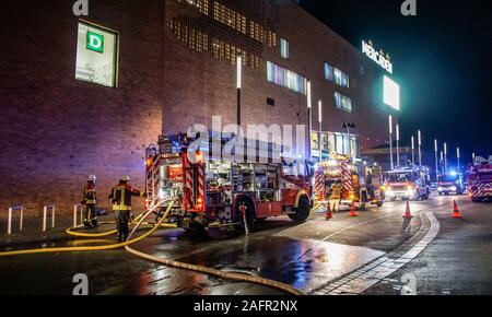 16 décembre 2019, Bade-Wurtemberg, Böblingen : Les pompiers sont debout devant un centre commercial. Trois voitures brûlées dans le parking à plusieurs étages d'un centre commercial à Böblingen. Photo : afp/Dettenmeyer/SDMG Banque D'Images