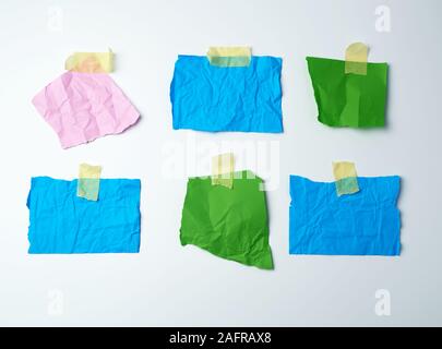 Multi-couleur vide morceaux de papier froissé sont collés avec du ruban adhésif sur un fond blanc Banque D'Images