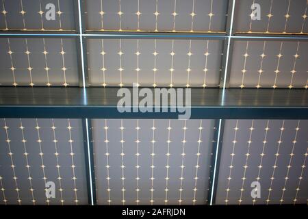 Dessous conception d'une installation de panneaux solaires l'énergie solaire sur le dessus de l'auvent garage de stationnement. Panneaux solaires transforment le rayonnement solaire en électricité et de fournir Banque D'Images