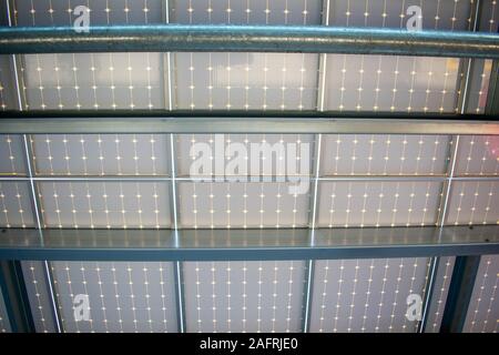 Dessous conception d'une installation de panneaux solaires l'énergie solaire sur le dessus de l'auvent garage de stationnement. Panneaux solaires transforment le rayonnement solaire en électricité et de fournir Banque D'Images