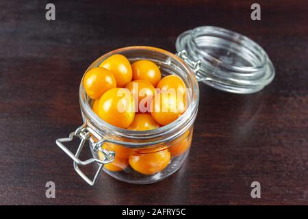 Physalis en coupe du verre sur table en bois Banque D'Images