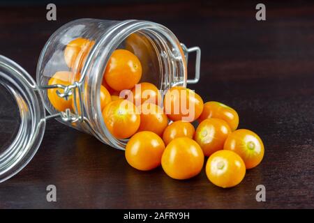 Physalis en coupe du verre sur table en bois Banque D'Images