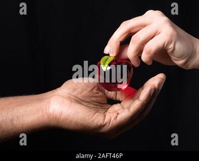 Main blanche en verre rouge donne à la main. L'Afrique apple La diversité ou la conception religieuse Banque D'Images