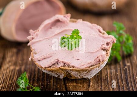 Rouleau avec Saucisson (cuisine allemande) sur une vieille table en bois comme détaillé close-up shot (selective focus) Banque D'Images