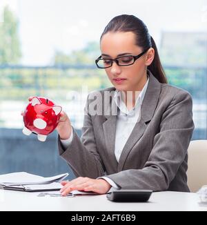 Le failli a businesswoman with piggy bank Banque D'Images