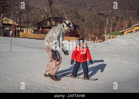 Père Fils enseigne la planche. Activités pour les enfants en hiver. Pour l'hiver. Vie Banque D'Images