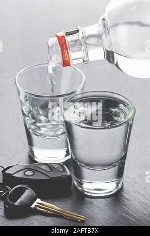 L'alcool est versé dans les verres et les clés de voiture sur fond sombre Banque D'Images