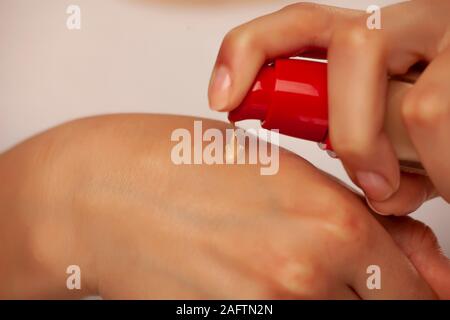 Femme sqeezing la pompe de liquide sur sa main Banque D'Images
