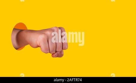 Jeune femme. Bâtonnets à la main hors du trou avec des arêtes vives sur fond jaune. L'égalité des droits pour les femmes concept. Copier sp Banque D'Images