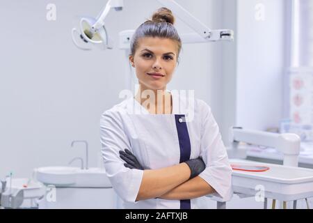 Portrait de jeune femme médecin dentiste sourire confiant, femme with arms crossed Banque D'Images