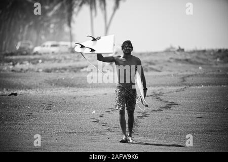 Portrait male surfer broken holding surfboard on beach Banque D'Images