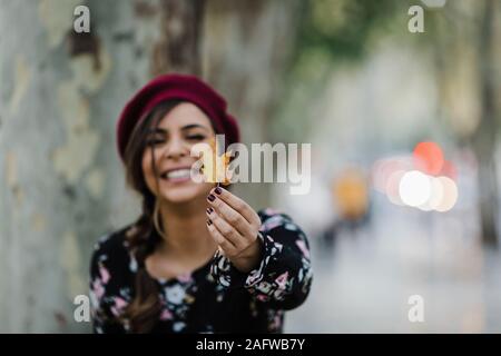 Portrait of happy young woman holding autumn leaf Banque D'Images