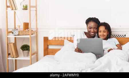 African American Woman and girl regarder les dessins animés Banque D'Images