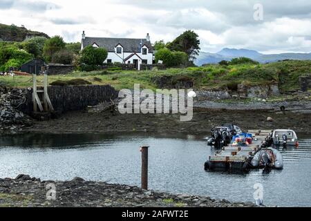 Les petits bateaux amarrés dans le port abrité sur Easdale Island au large de la côte ouest de l'Ecosse. Banque D'Images