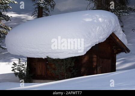 Cabane en bois massif avec couche de neige sur le toit. Près de la station de ski Kaunertal road, Tyrol, dans les Alpes autrichiennes. Banque D'Images
