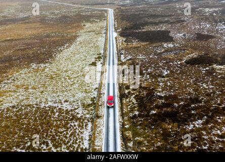 Red Royal Mail poster van conduite sur neige couverts rural road through the Quaich Glen en Ecosse, Royaume-Uni Banque D'Images