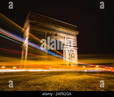 Vue à temps de sentiers lumineux autour de l'Arc de Triomphe à Paris, France. Banque D'Images